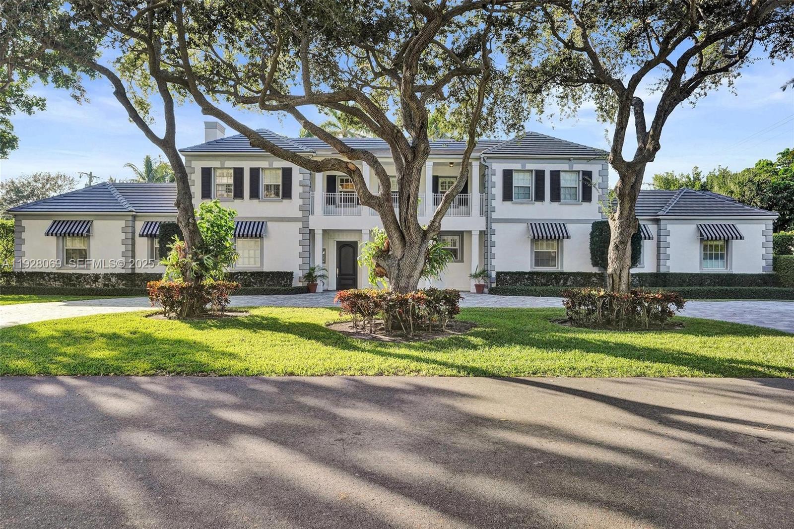 1281 Banyan Road Boca Raton, FL 33432 - Photo 9 of 69 a front view of a house with a yard and a porch