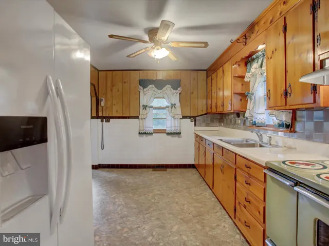 a kitchen with stainless steel appliances granite countertop a sink a stove and a refrigerator