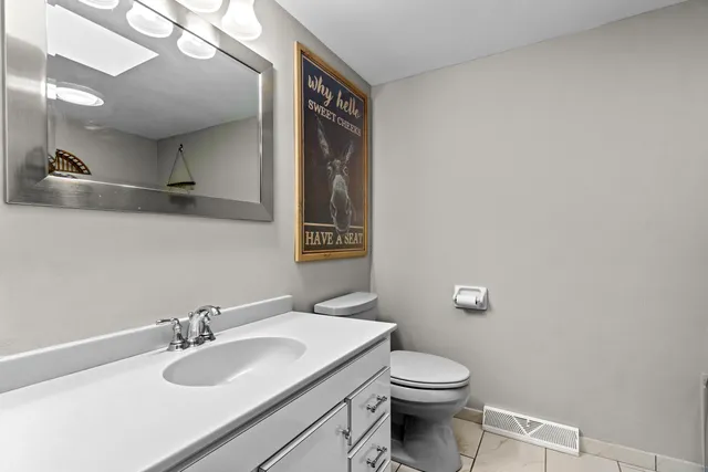 a bathroom with a sink vanity mirror and toilet