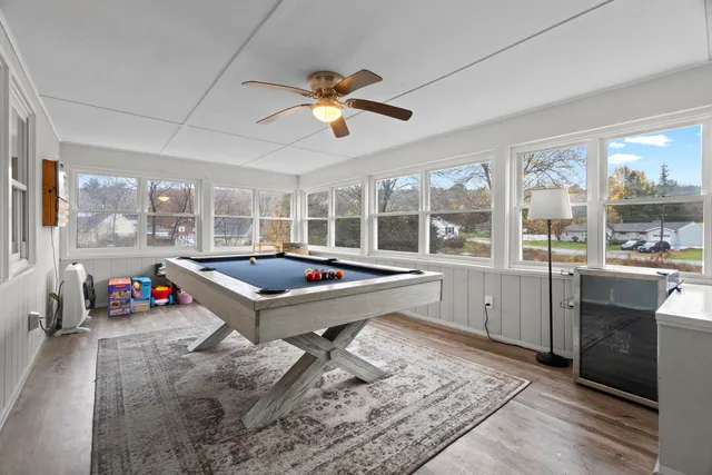 a living room with furniture pool table and a large window