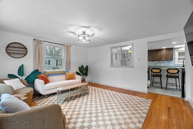 a living room with furniture a flat screen tv and a window