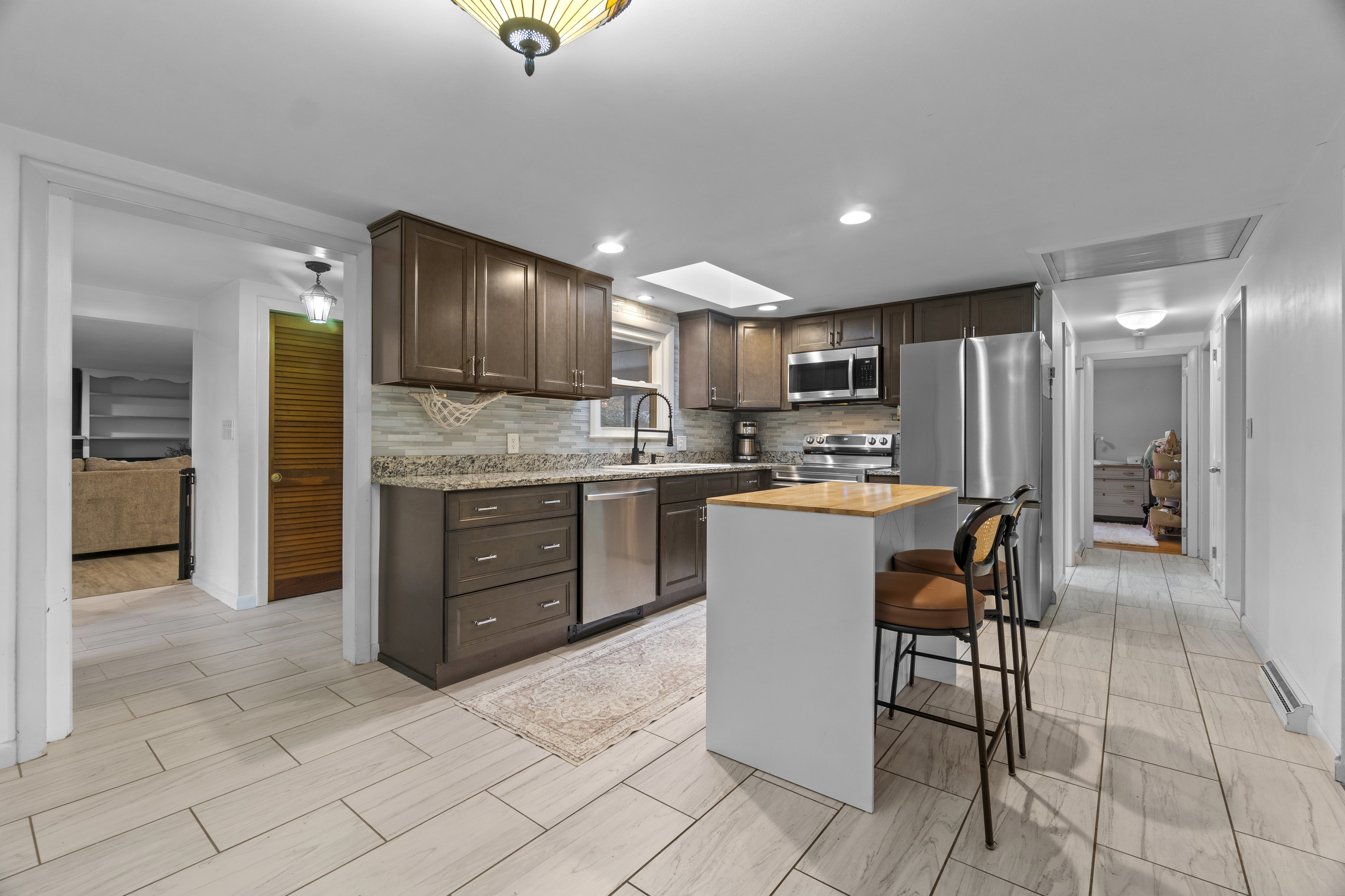 10 Green Acres Lane Thompson, CT 06255 - Photo 9 of 40 a kitchen with kitchen island granite countertop wooden cabinets a sink a stove a oven and a refrigerator