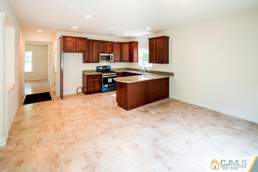 388 Aldrich Road Howell, NJ 07731 - Photo 7 of 24 a large kitchen with stainless steel appliances kitchen island granite countertop a refrigerator and a sink