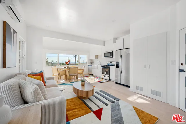 a living room with furniture and a view of kitchen