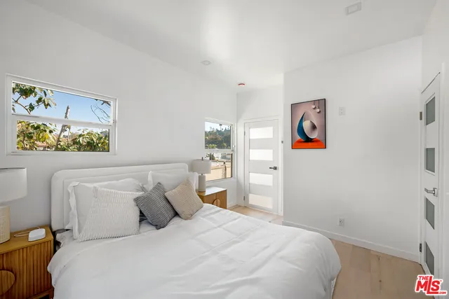 a bedroom with a bed and painting on the wall
