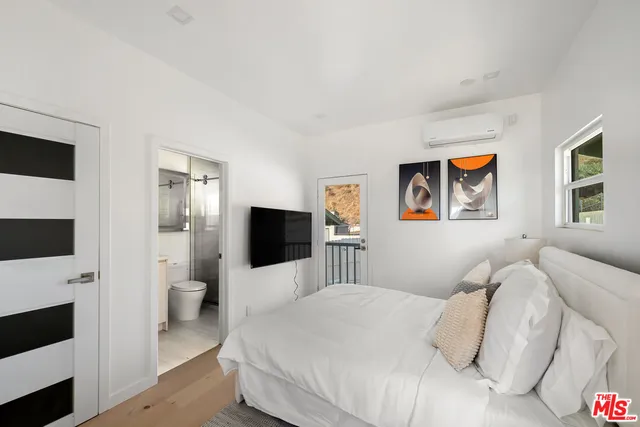 a bedroom with a bed and a flat screen tv