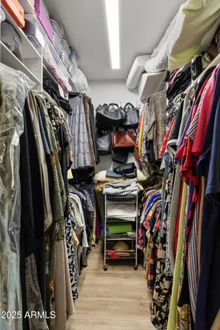a view of walk in closet with clothes and shoes