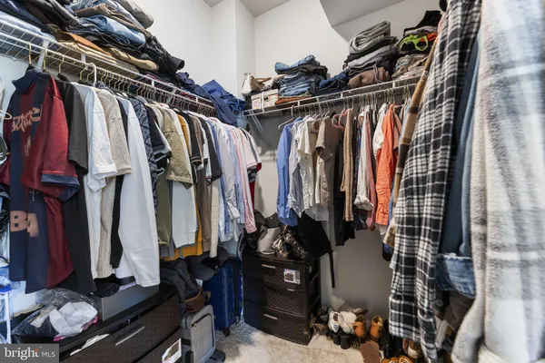 a view of walk in closet with clothes and shoes