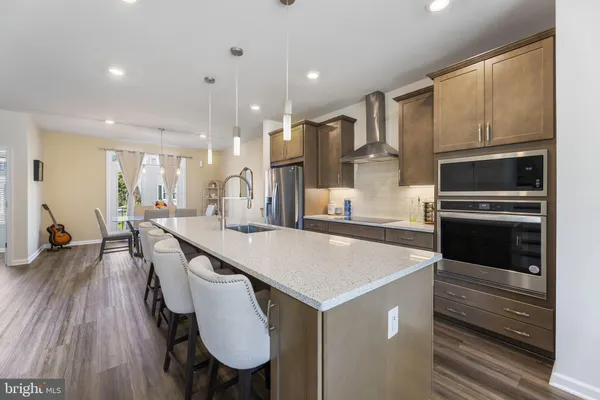 a large kitchen with a table chairs refrigerator and microwave