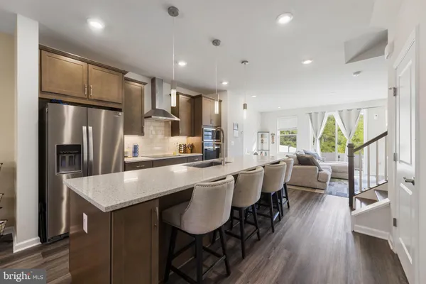 a large kitchen with kitchen island a large window a center island stainless steel appliances cabinets and furniture