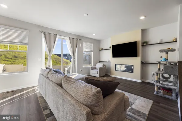 a living room with furniture a flat screen tv and a large window