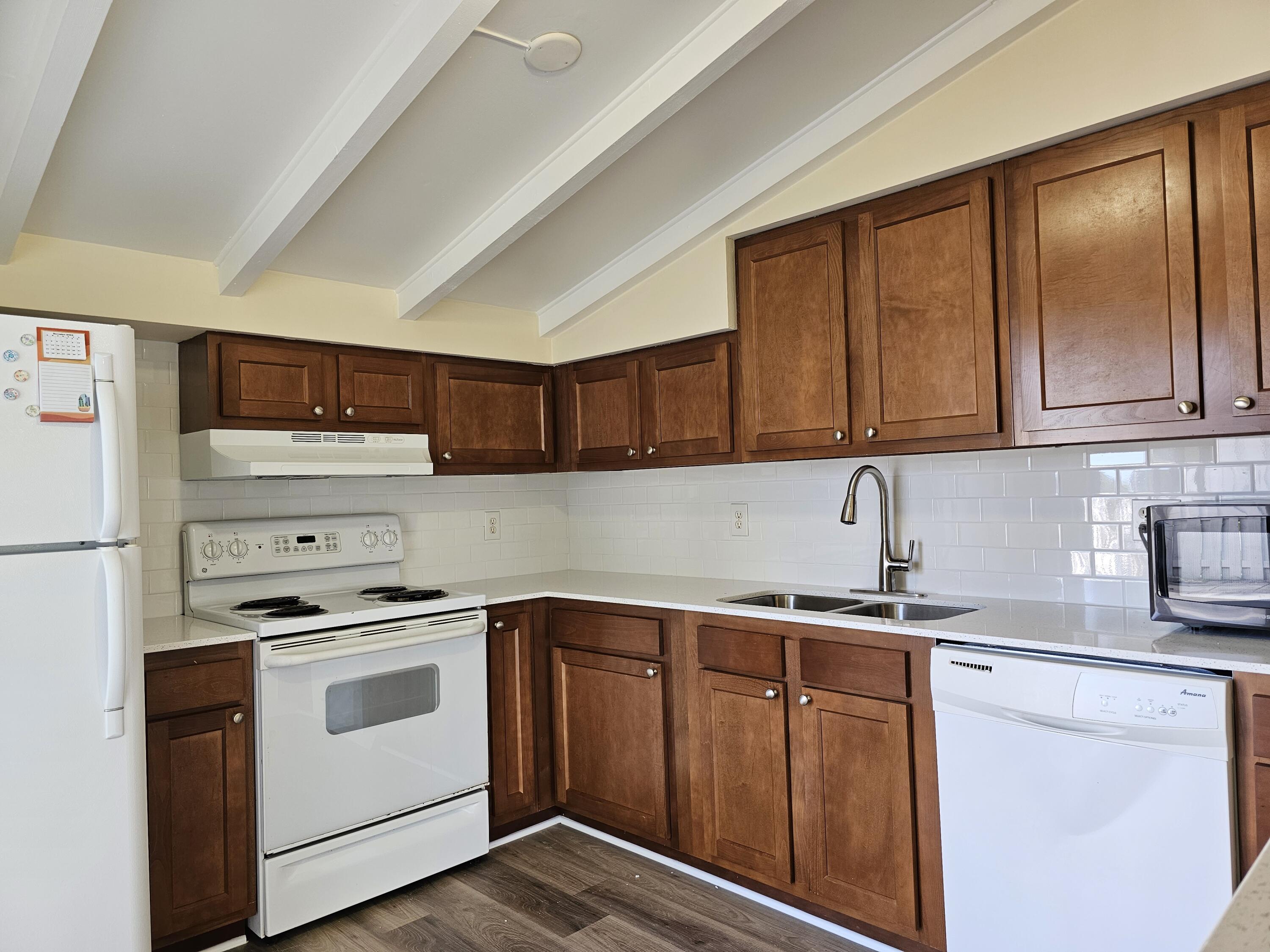 a kitchen with stainless steel appliances granite countertop a sink stove and refrigerator with wooden cabinets