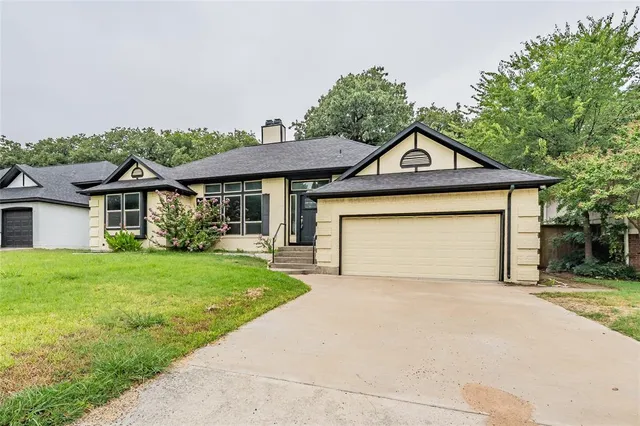 a front view of a house with yard and parking