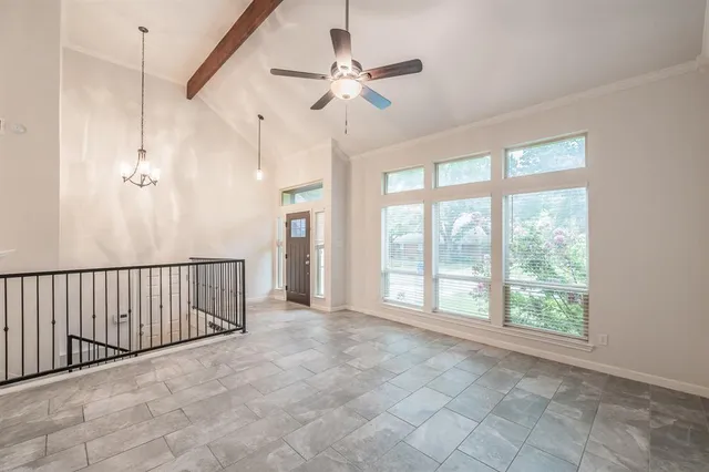 a view of a livingroom with a chandelier fan and windows