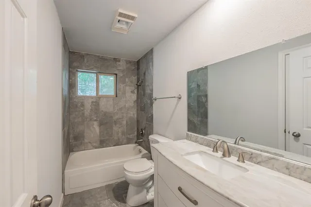 an empty room with a ceiling fan and window