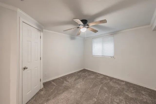 an empty room with a ceiling fan and a window
