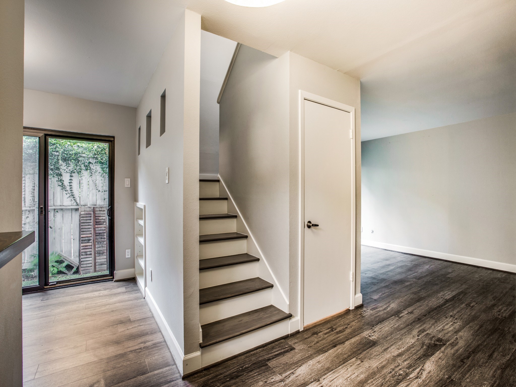 a view of a hallway with wooden floor and entryway