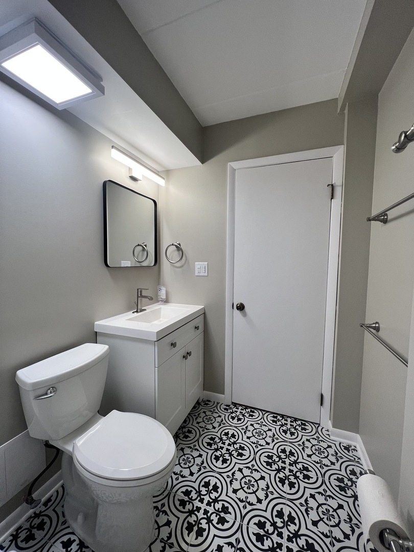 3330 Grove Avenue, Unit 1N Berwyn, IL 60402 - Photo 2 of 20 a bathroom with a toilet sink vanity and mirror