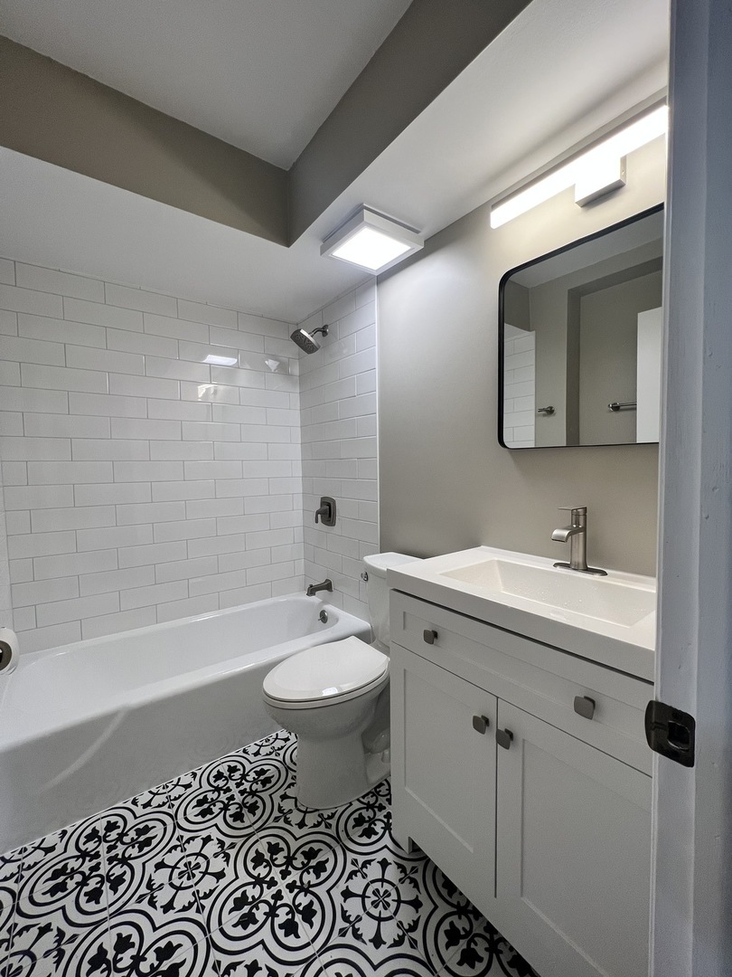 3330 Grove Avenue, Unit 1N Berwyn, IL 60402 - Photo 3 of 20 a bathroom with a double vanity sink mirror and bathtub