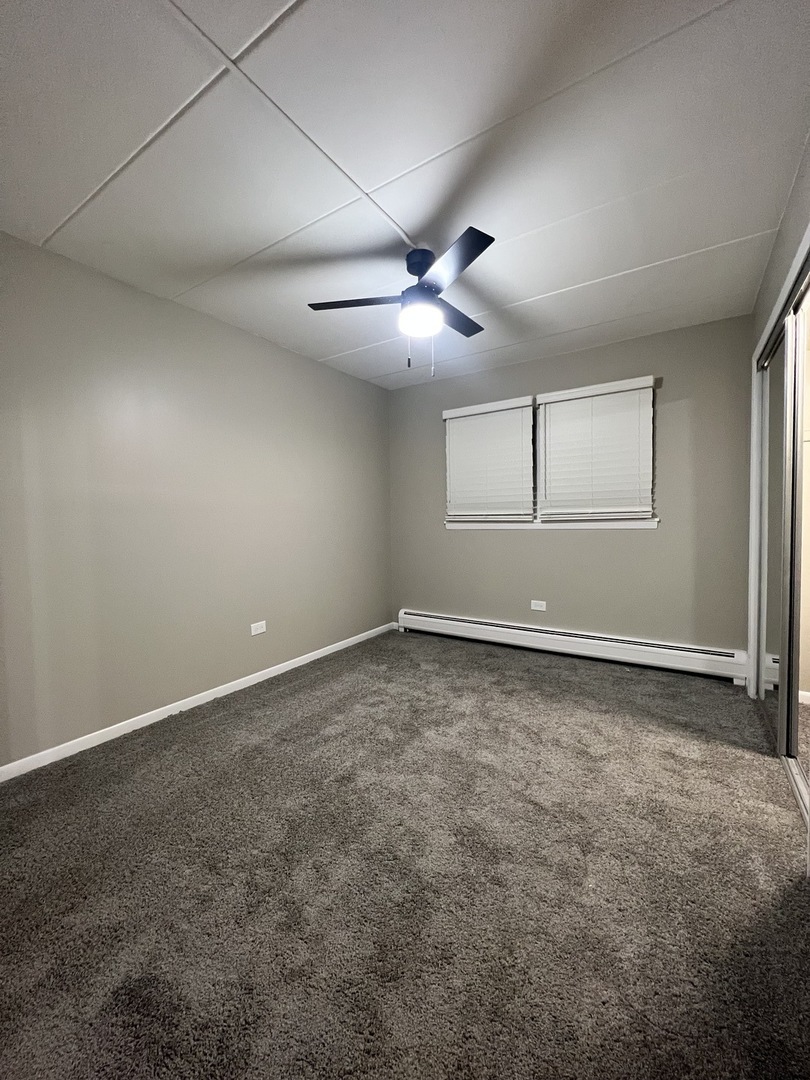 3330 Grove Avenue, Unit 1N Berwyn, IL 60402 - Photo 8 of 20 an empty room with a ceiling fan and window