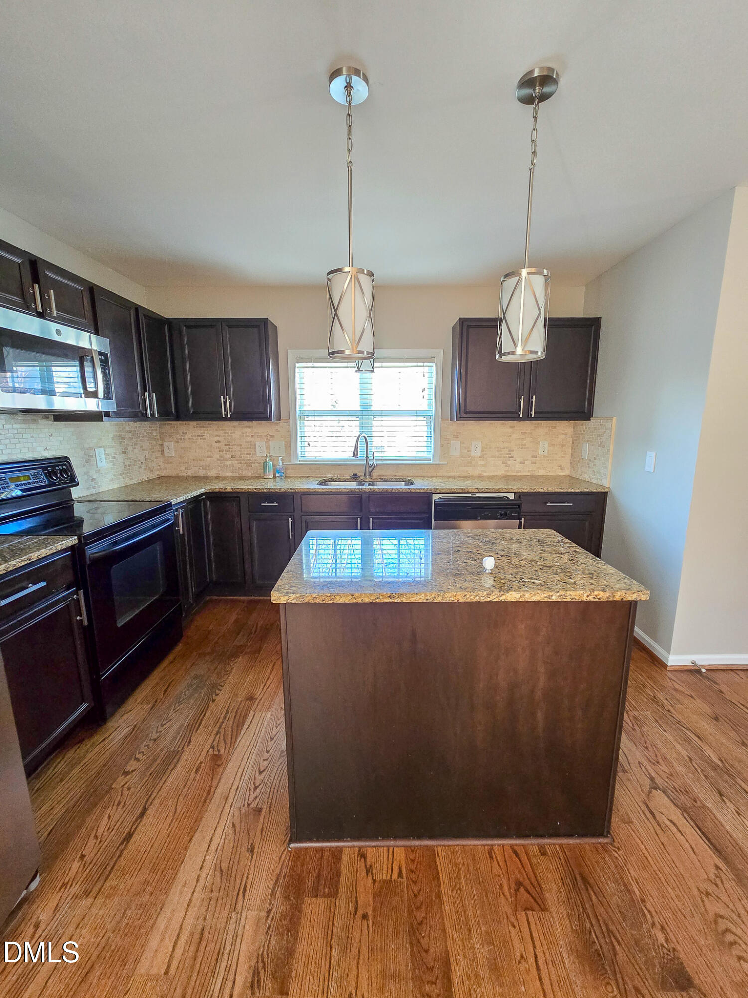 1133 South State Street Raleigh, NC 27601 - Photo 12 of 34 a view of a kitchen with kitchen island a stove a wooden floor and a window