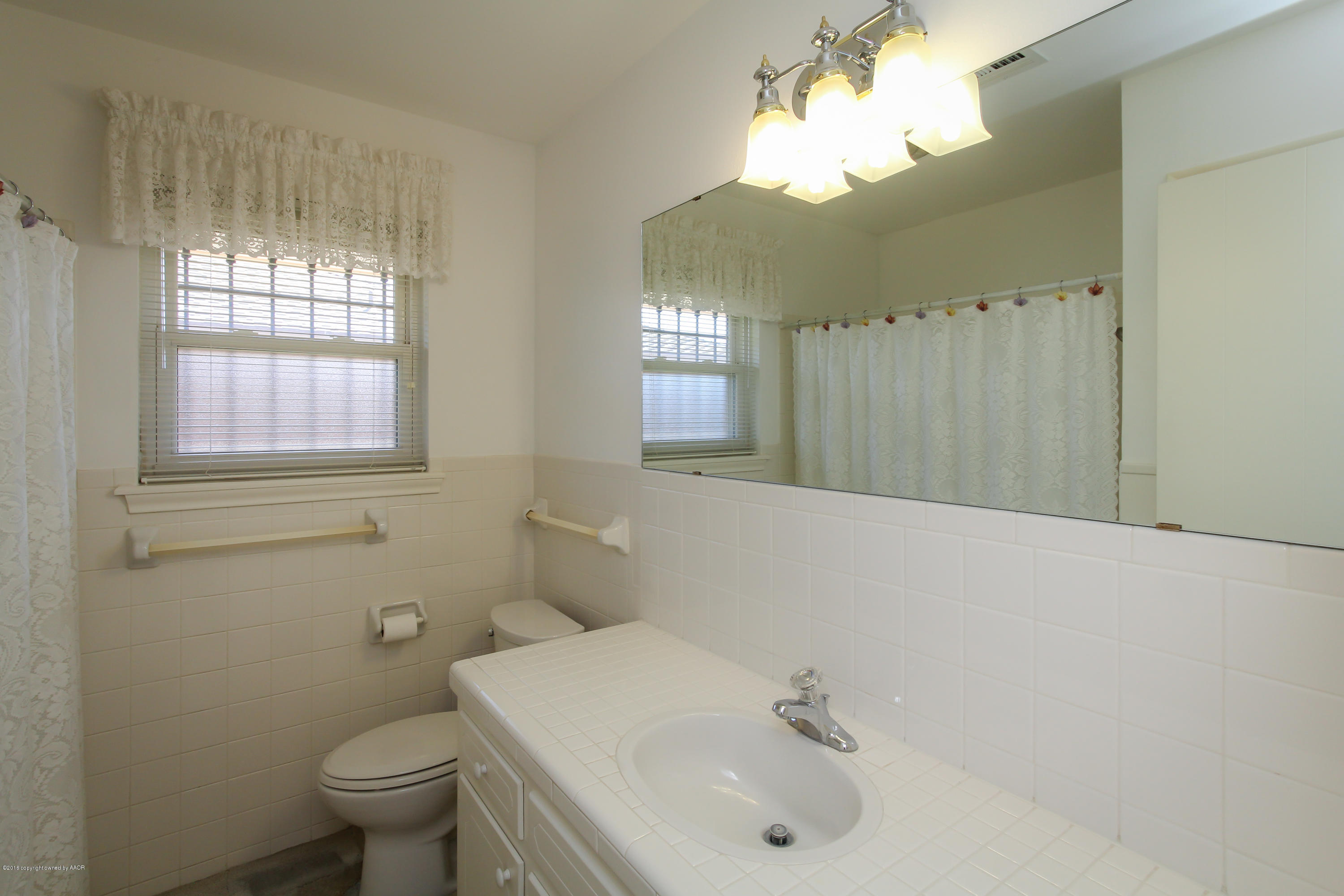 7012 Dreyfuss Road Amarillo, TX 79106 - Photo 12 of 39 a bathroom with a sink a toilet and a mirror