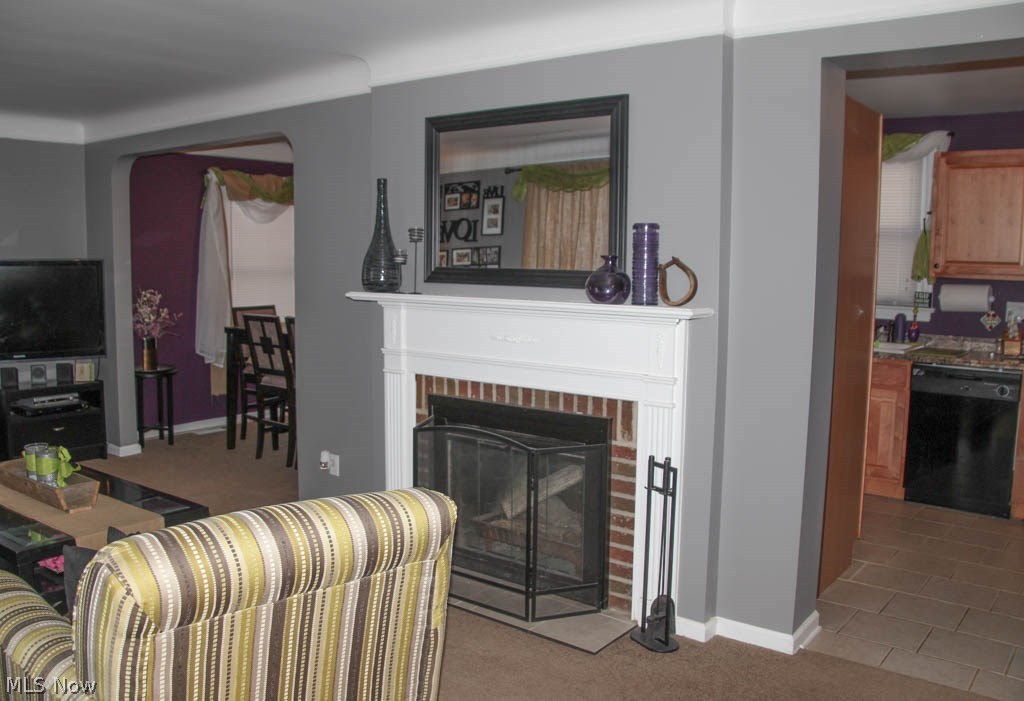 4996 Anderson Road Cleveland, OH 44124 - Photo 7 of 26 View of living room with a wood burning fireplace looking into the kitchen and dining room.