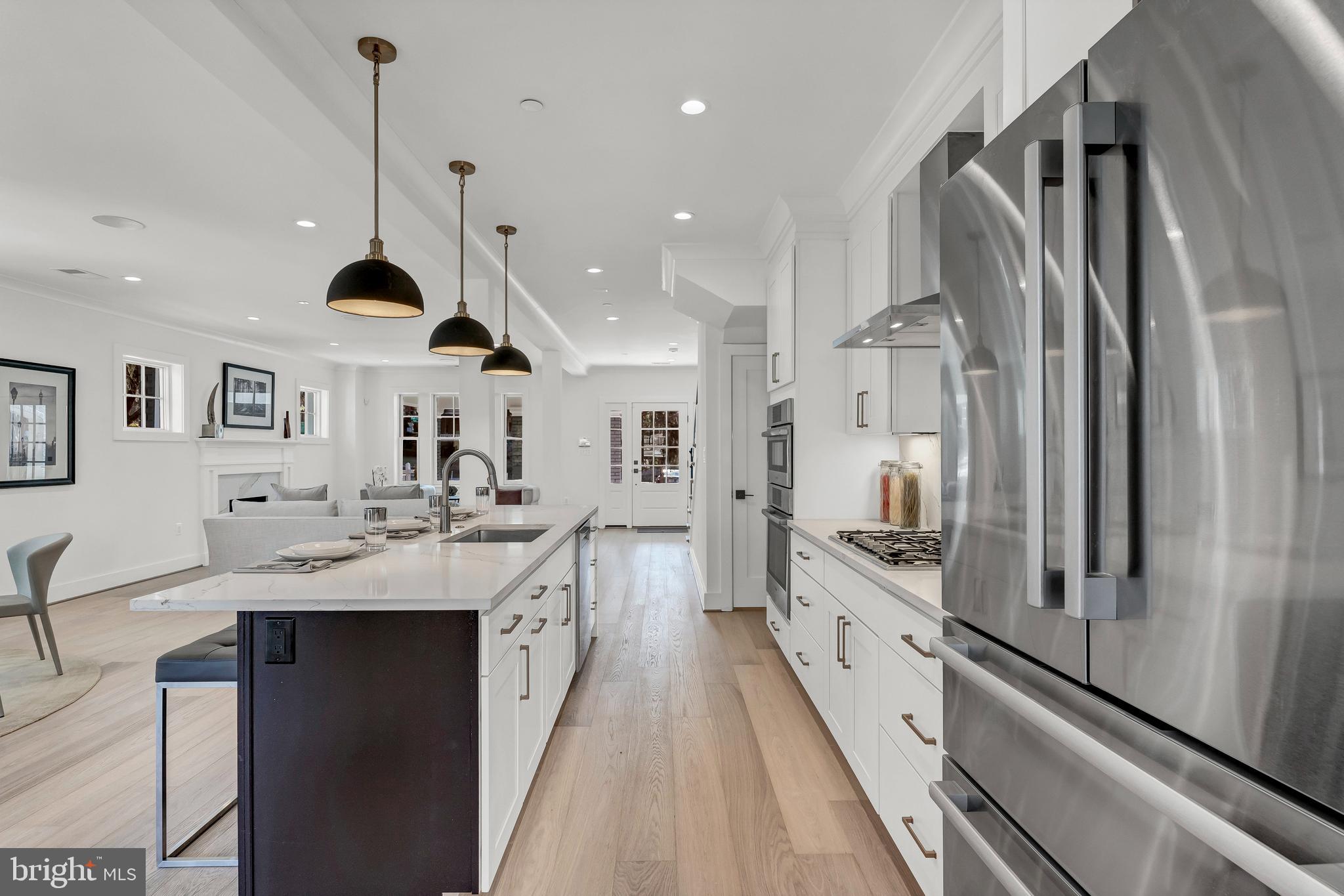 2001 Klingle Road Northwest Washington, DC 20010 - Photo 18 of 50 a large kitchen with stainless steel appliances kitchen island a large counter top a sink a stove and a refrigerator