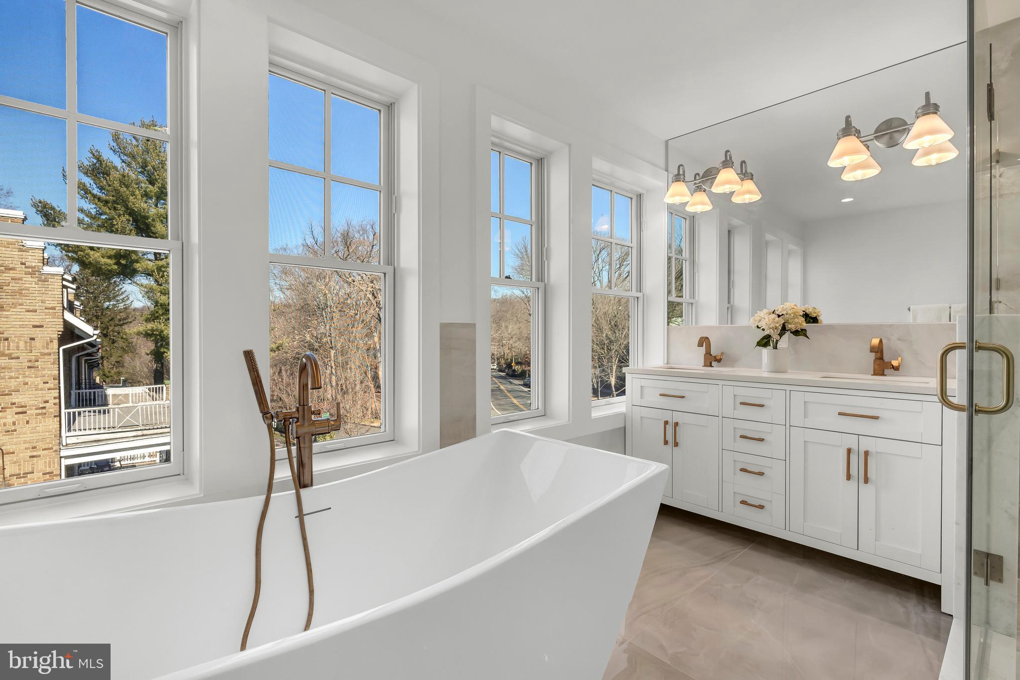 2001 Klingle Road Northwest Washington, DC 20010 - Photo 36 of 50 a spacious bathroom with a double vanity sink a mirror a bathtub and a shower