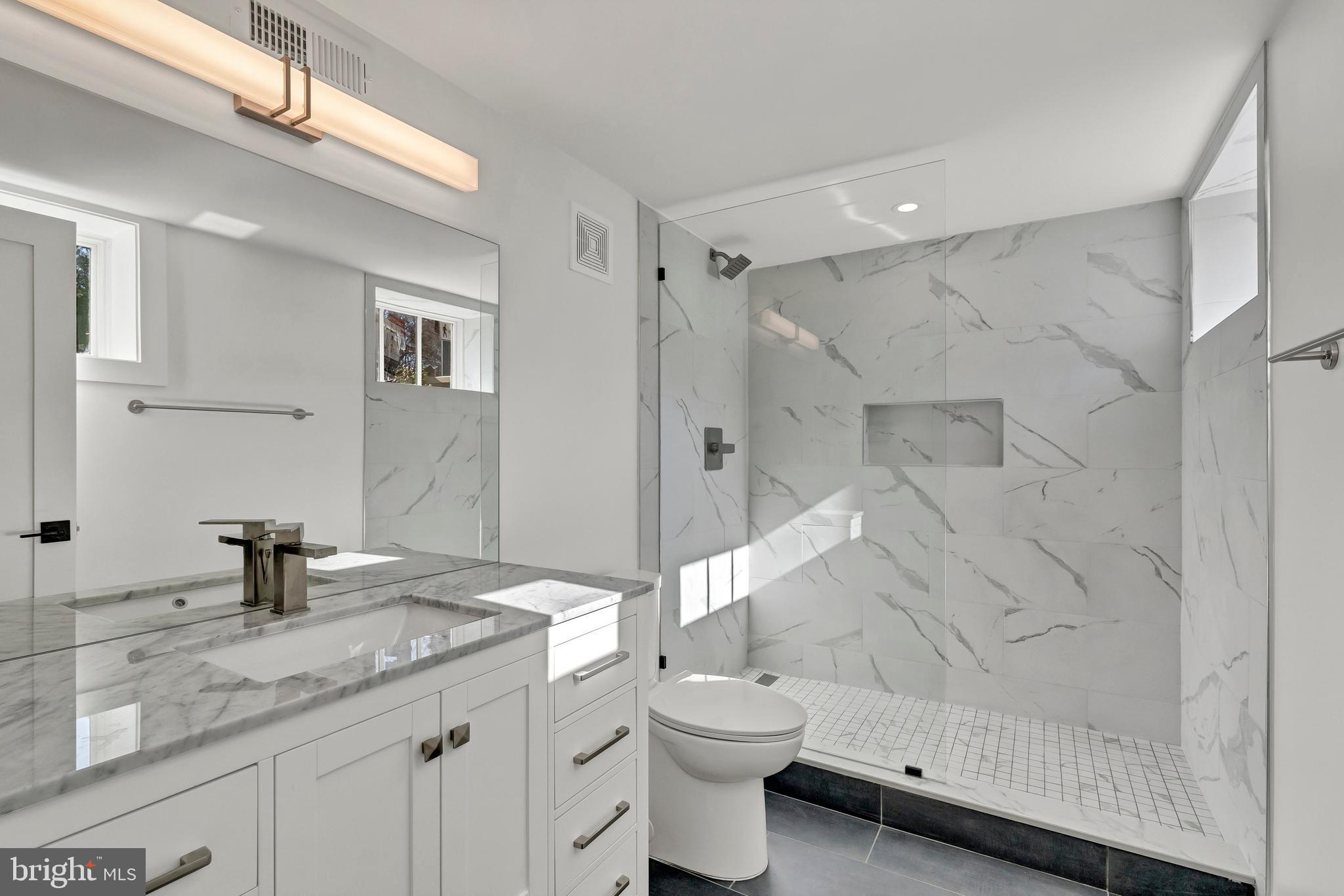2001 Klingle Road Northwest Washington, DC 20010 - Photo 45 of 50 a bathroom with a granite countertop sink toilet and shower