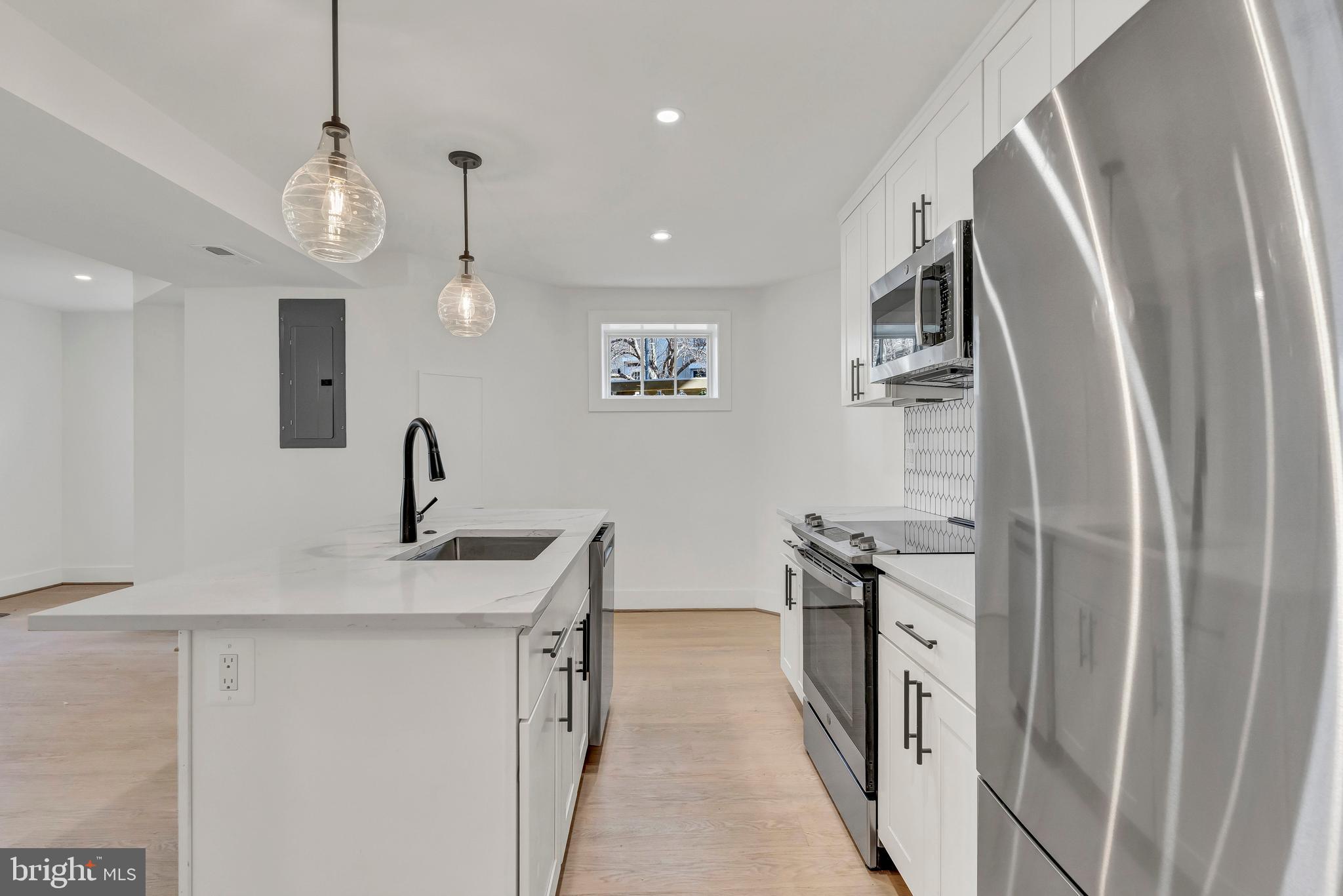 2001 Klingle Road Northwest Washington, DC 20010 - Photo 47 of 50 a kitchen with stainless steel appliances granite countertop a sink a stove and a refrigerator