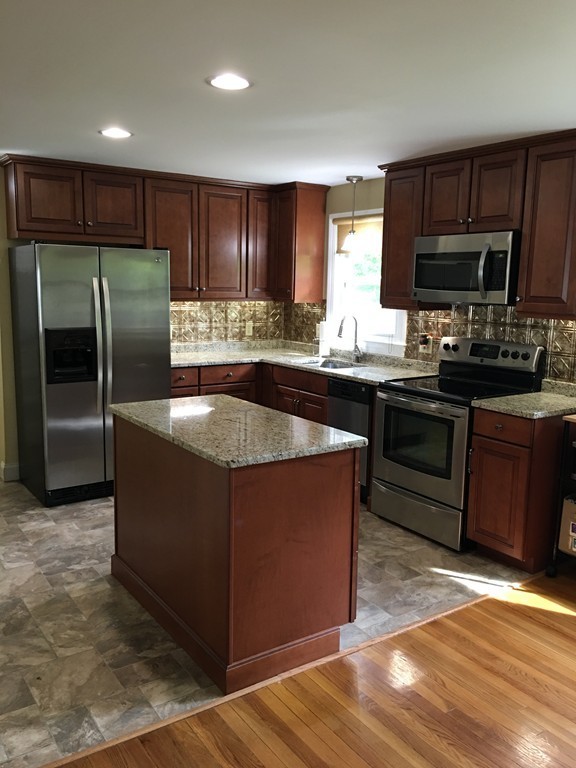 66 Lancaster Road Clinton, MA 01510 - Photo 3 of 19 a kitchen with stainless steel appliances granite countertop a stove a sink dishwasher a refrigerator and a microwave oven with wooden cabinets