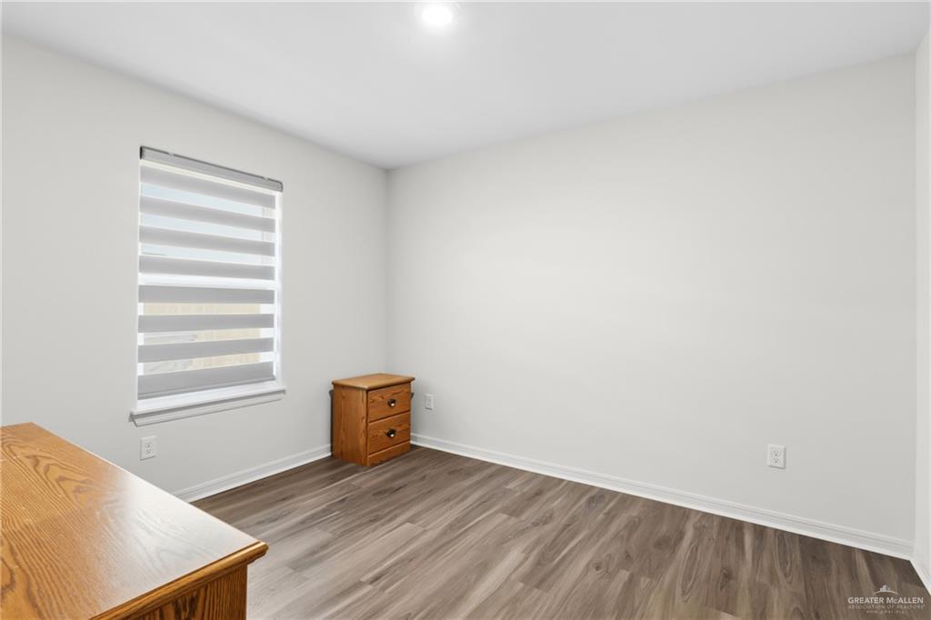 14221 Chalk Rdg Drive McAllen, TX 78504 - Photo 7 of 17 a view of an empty room with wooden floor and a window
