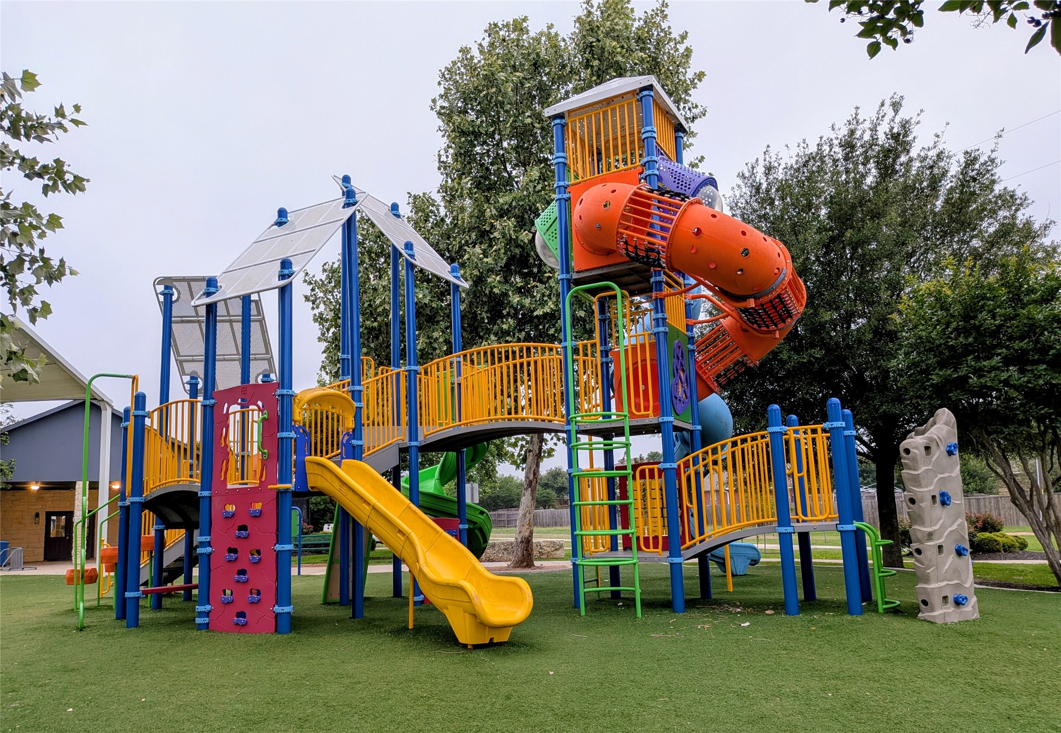 212 Foster Lane Jarrell, TX 76537 - Photo 23 of 26 A vibrant playground structure on synthetic turf, offering multiple slides and climbing features.