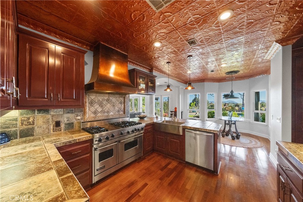 39817 Calle Cabernet Temecula, CA 92591 - Photo 51 of 75 a kitchen with stainless steel appliances granite countertop a stove a sink and a refrigerator