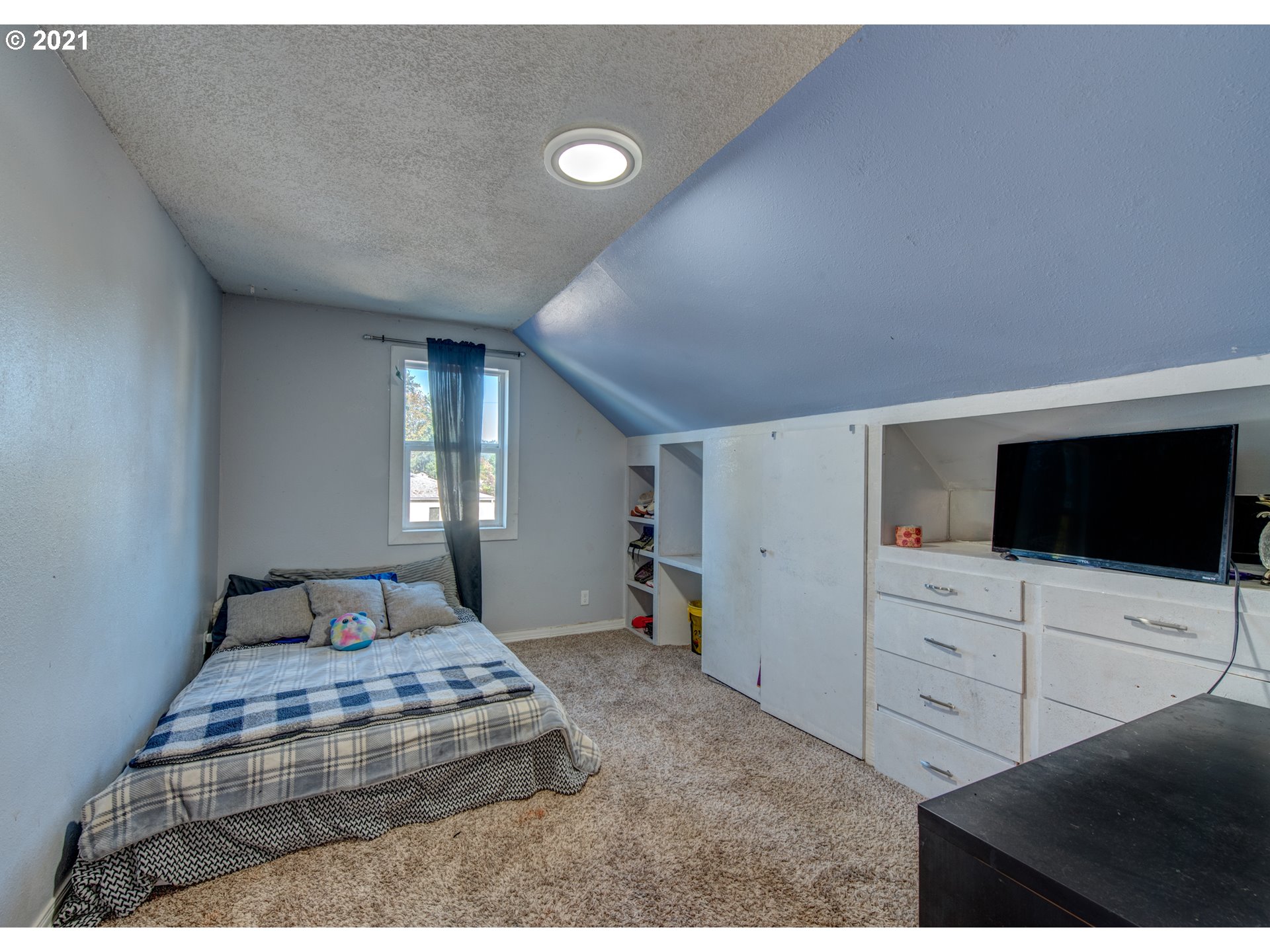580 54th Street Springfield, OR 97478 - Photo 22 of 31 a bedroom with a bed and a flat tv screen on wall