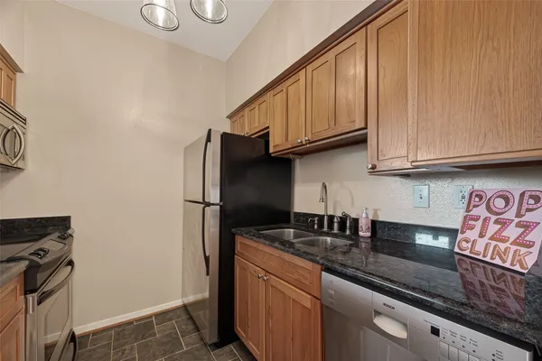 a kitchen with stainless steel appliances granite countertop a sink stove and refrigerator