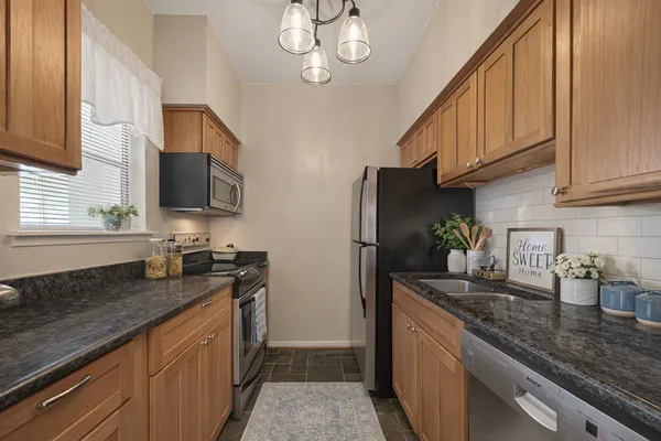 a kitchen with stainless steel appliances granite countertop a sink refrigerator and microwave