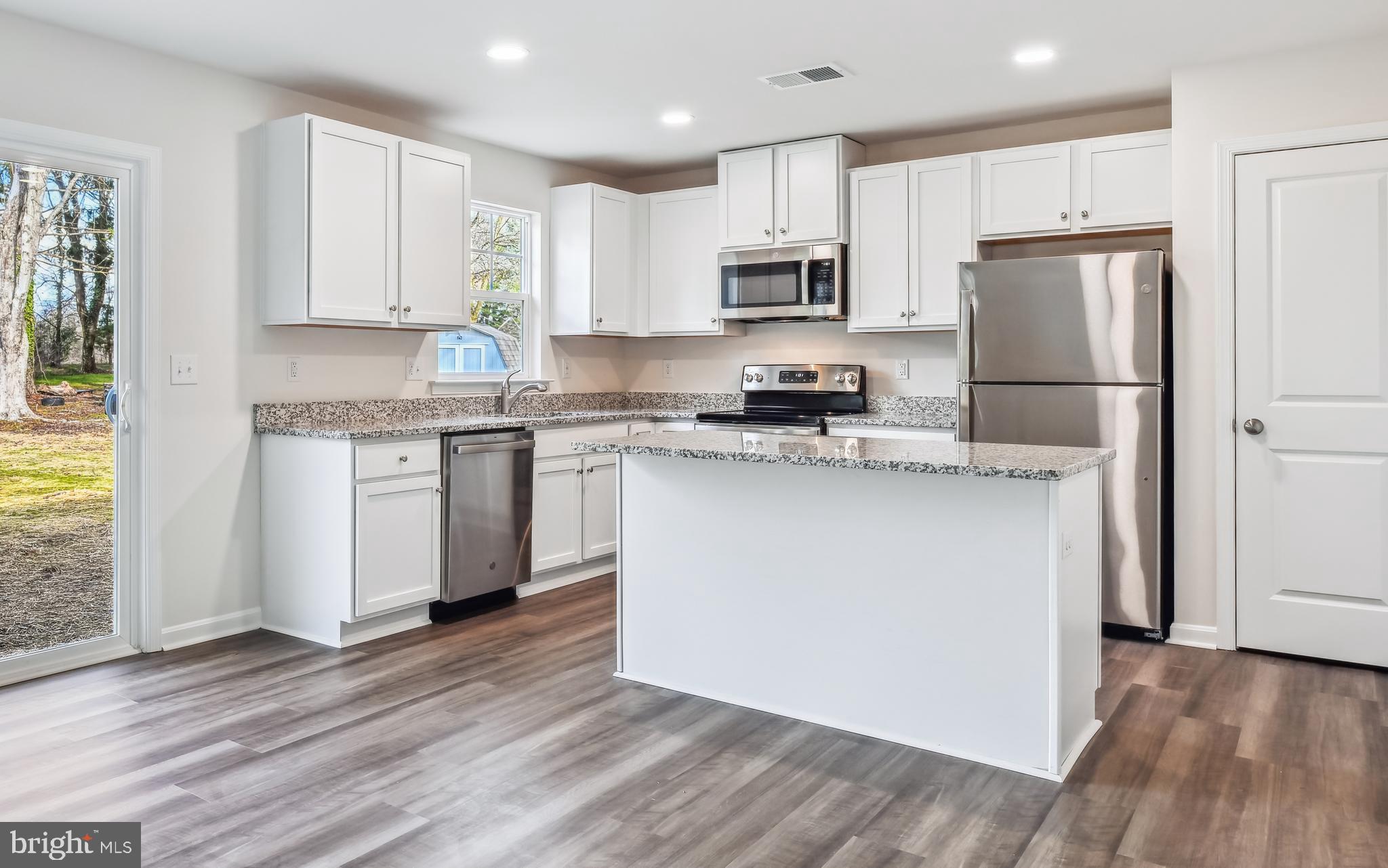 11235 Lord Baltimore Drive Issue, MD 20645 - Photo 3 of 23 a kitchen with stainless steel appliances granite countertop a stove top oven a refrigerator a sink and white cabinets with wooden floor