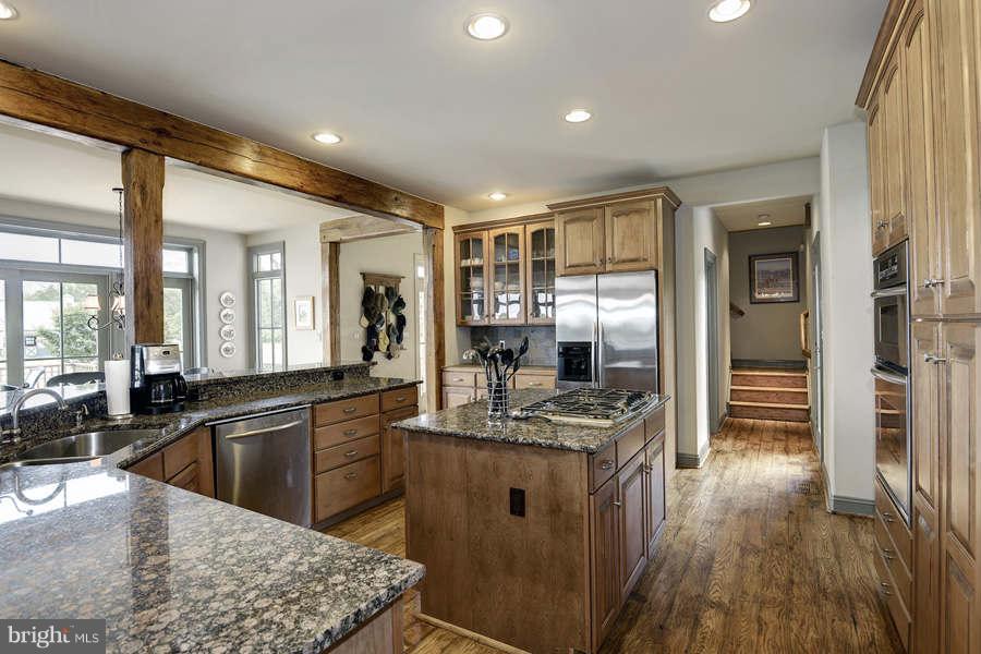 14527 Partnership Road Poolesville, MD 20837 - Photo 15 of 30 a kitchen with stainless steel appliances granite countertop a sink stove and wooden cabinets
