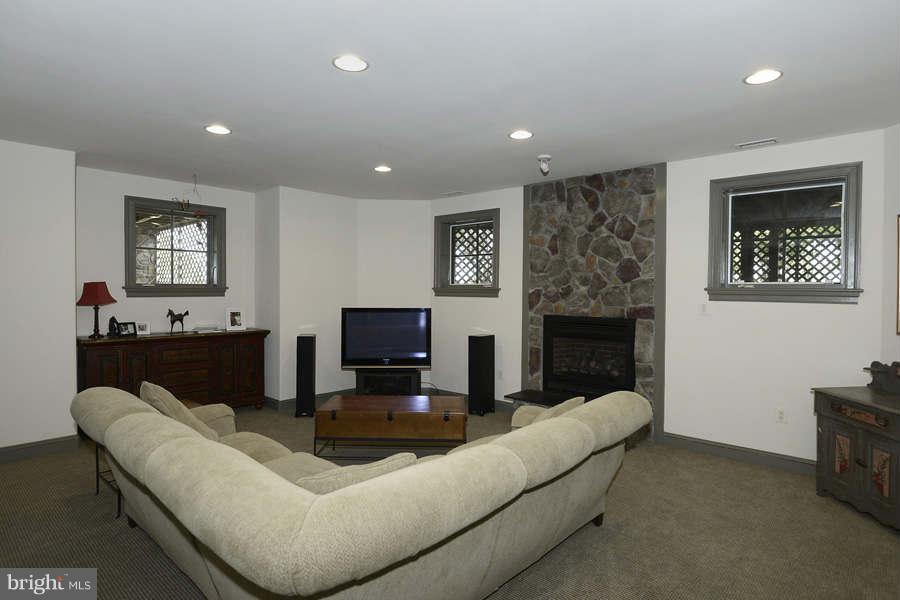 14527 Partnership Road Poolesville, MD 20837 - Photo 28 of 30 a living room with furniture a fireplace and a flat screen tv