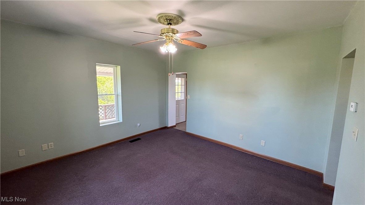Unfurnished room with ceiling fan, baseboards, and carpet floors