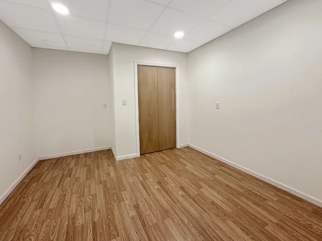 a view of an empty room with wooden floor