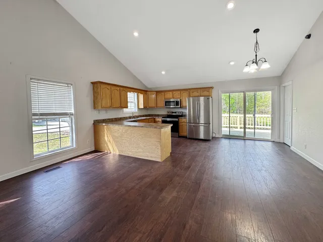 a view of a kitchen with stove and wooden floor