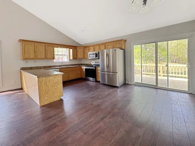 a kitchen with stainless steel appliances wooden floors and large window
