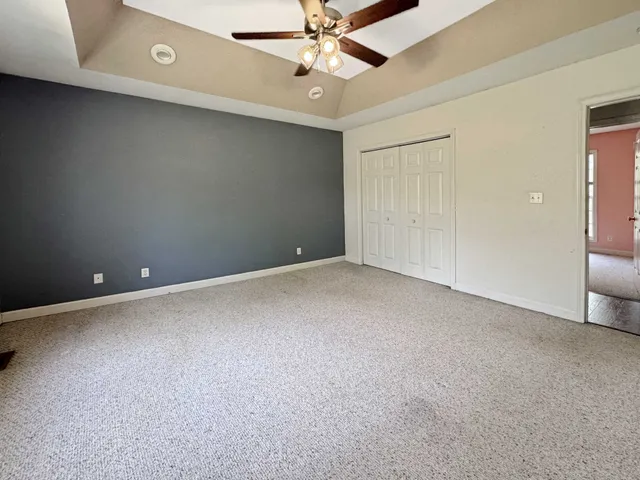 an empty room with a ceiling fan and a window