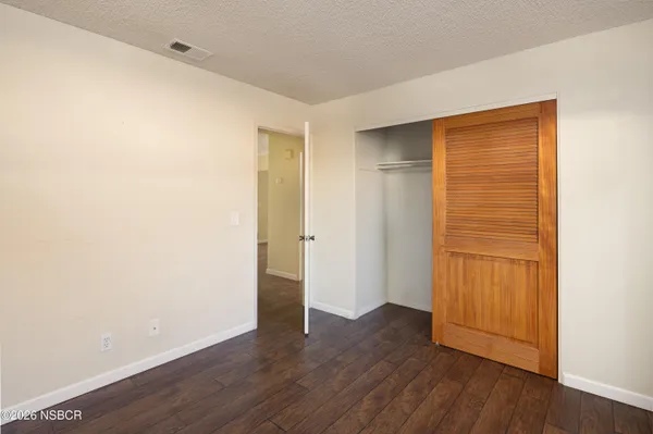 a view of an empty room with wooden floor