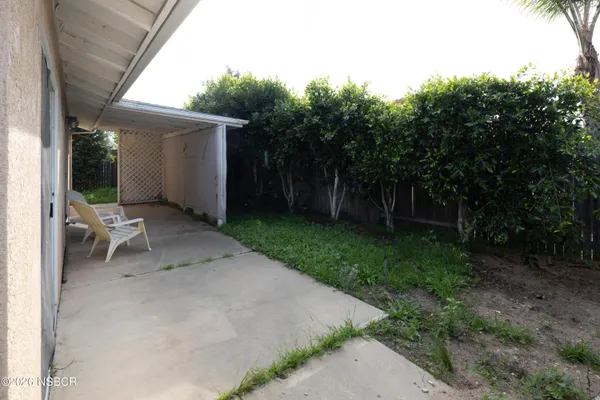 a view of a chair and table in backyard of the house
