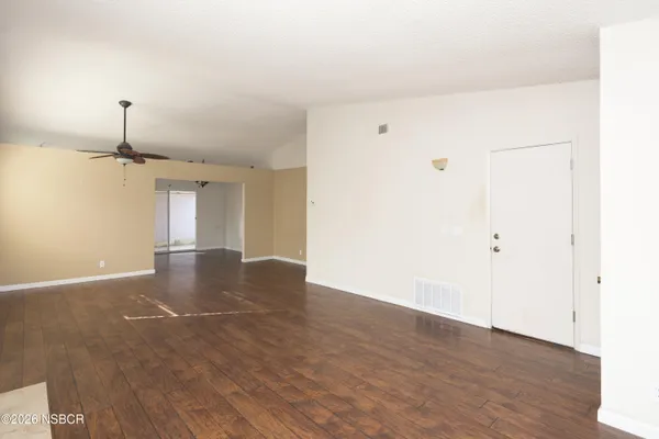 a view of empty room with wooden floor