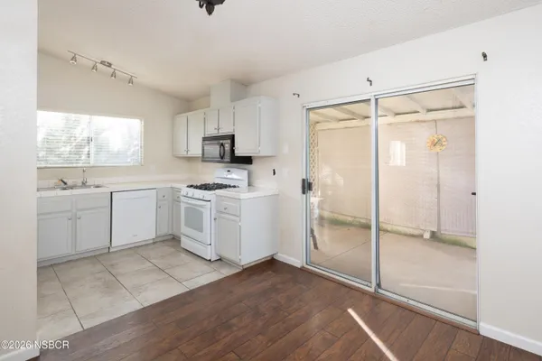 a kitchen with white cabinets and white appliances